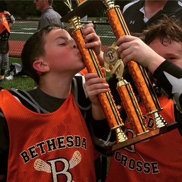 Cochlear recipient Christian kissing his trophy