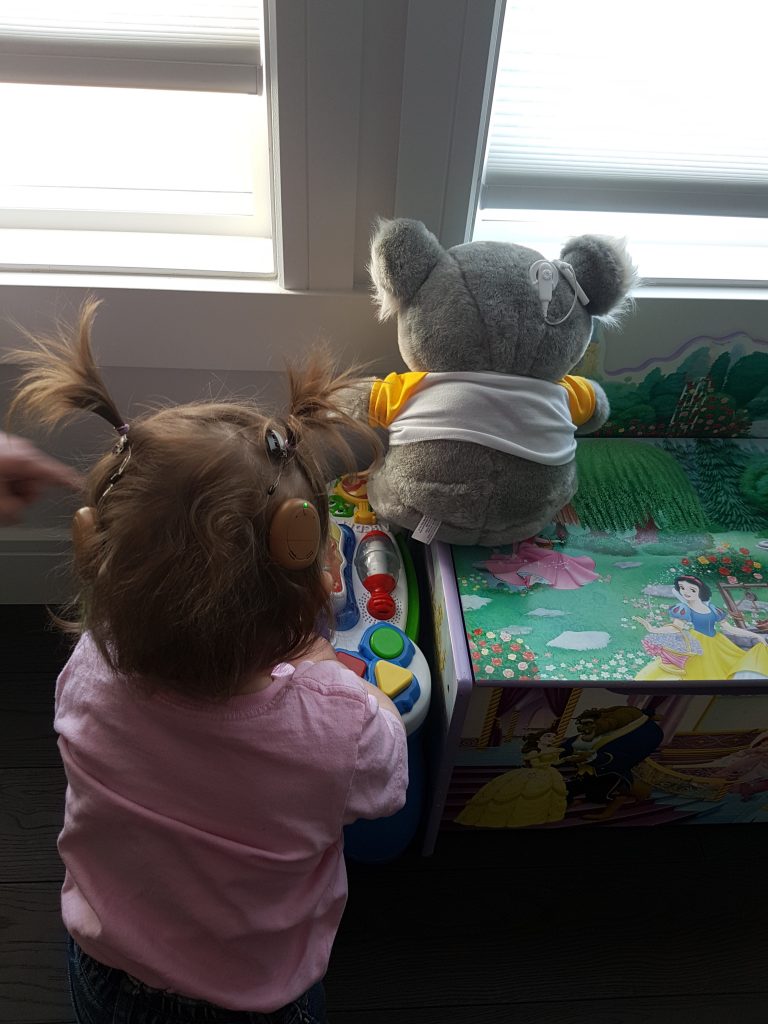 Kanso sound recipient Elsie playing with koala teddy