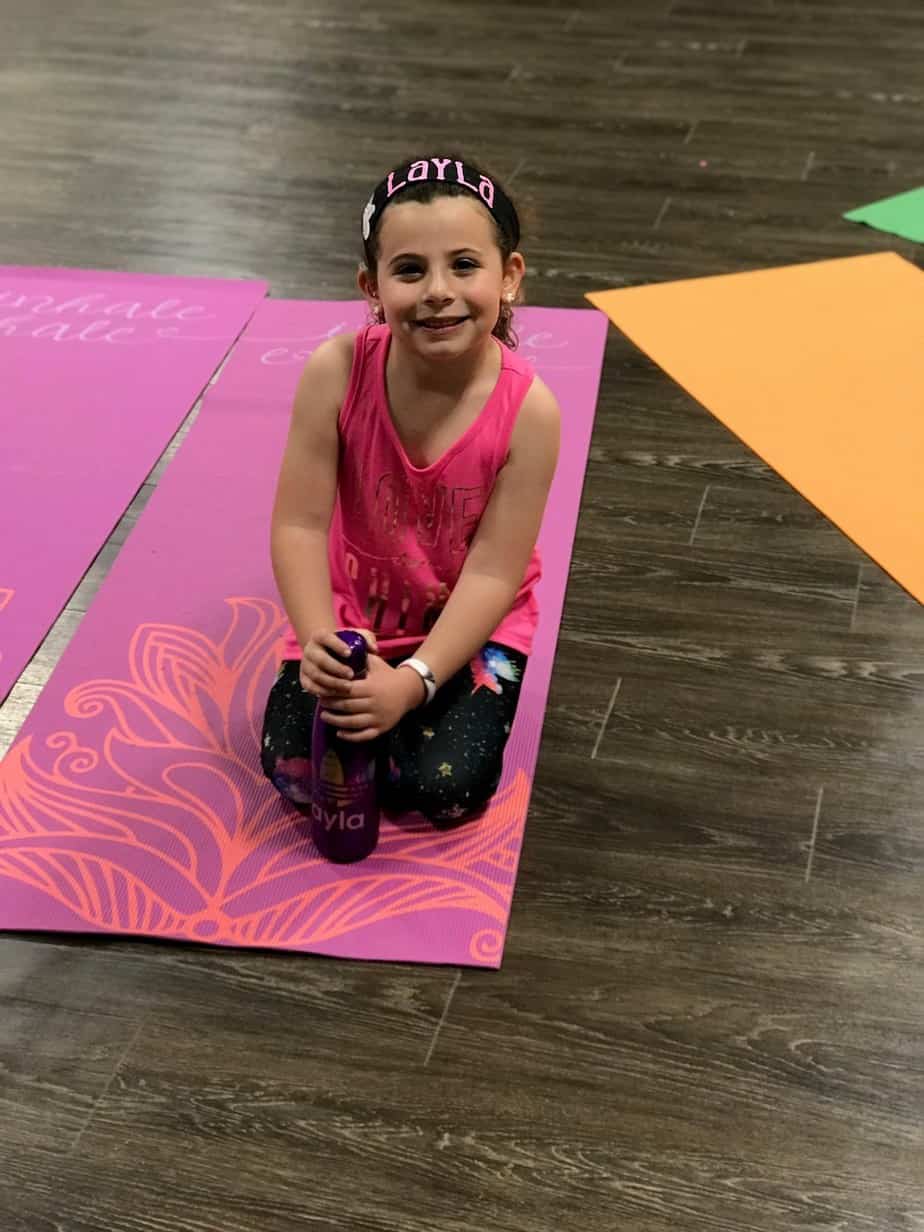 Layla doing yoga, who has hearing loss present at birth