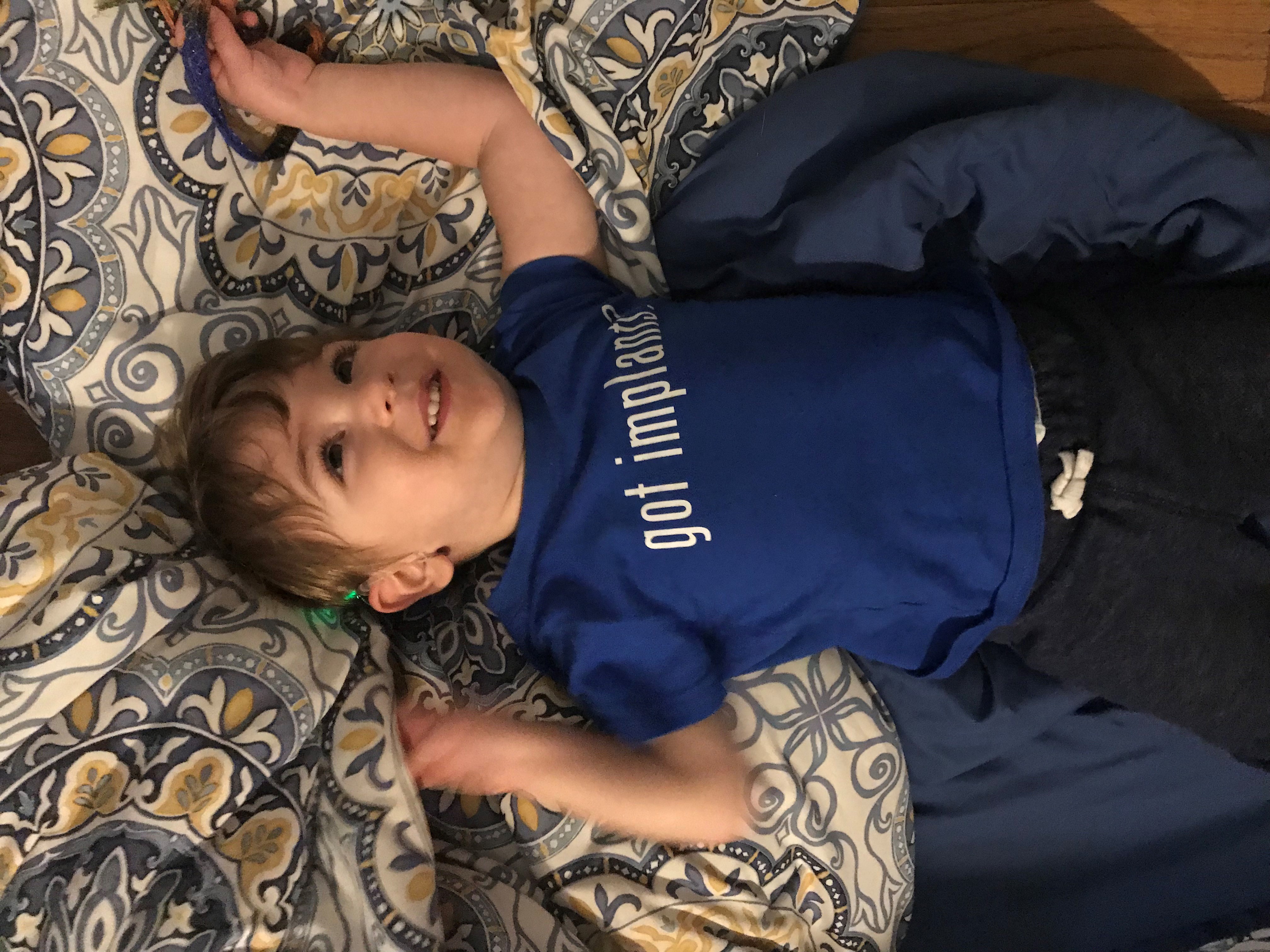 Levi, who is a child with hearing loss, with his got implants shirt