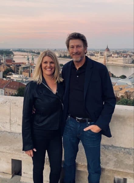 Barry and his wife stand outside on their vacation. Barry has been traveling with a cochlear implant.