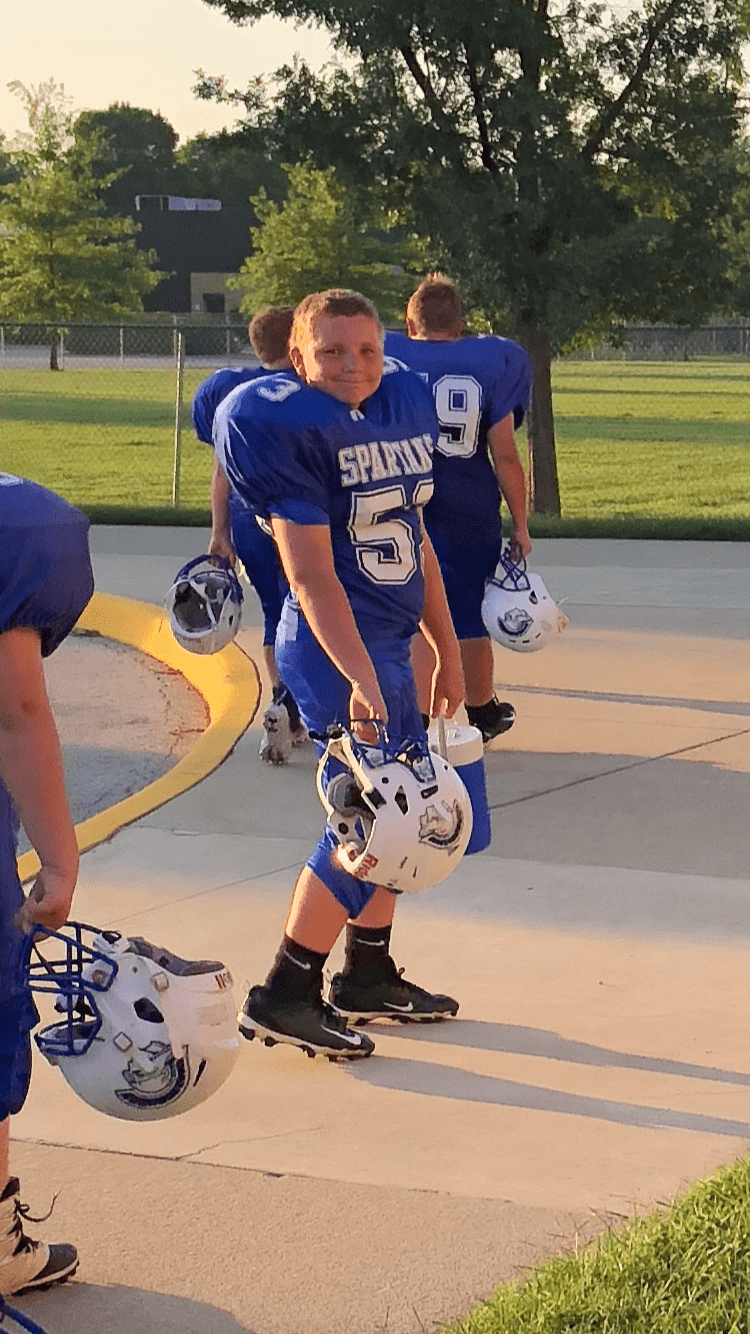 Andrew who had hearing early intervention, playing football