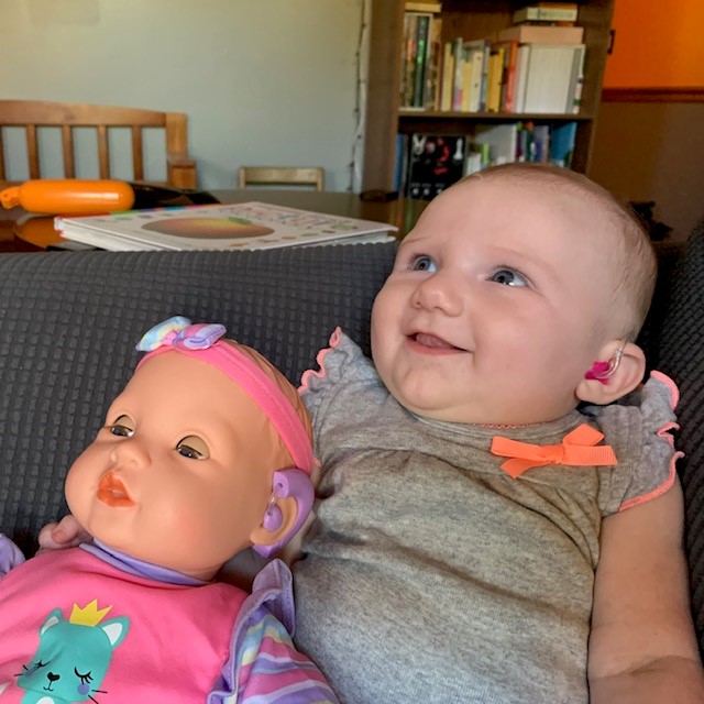 Bridget, who has hearing loss and EVA, with a doll