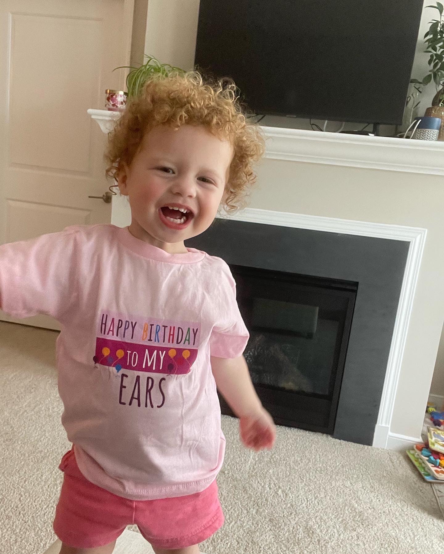 Cece, a child with profound hearing loss, with a birthday shirt