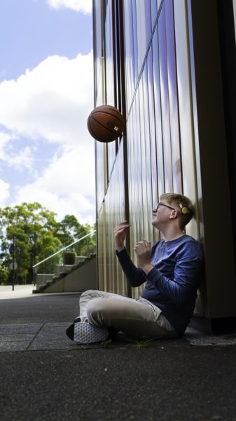 Jack sits with a basketball in hand proud to wear his Halo accessory for Kanso 2 Sound Processor.