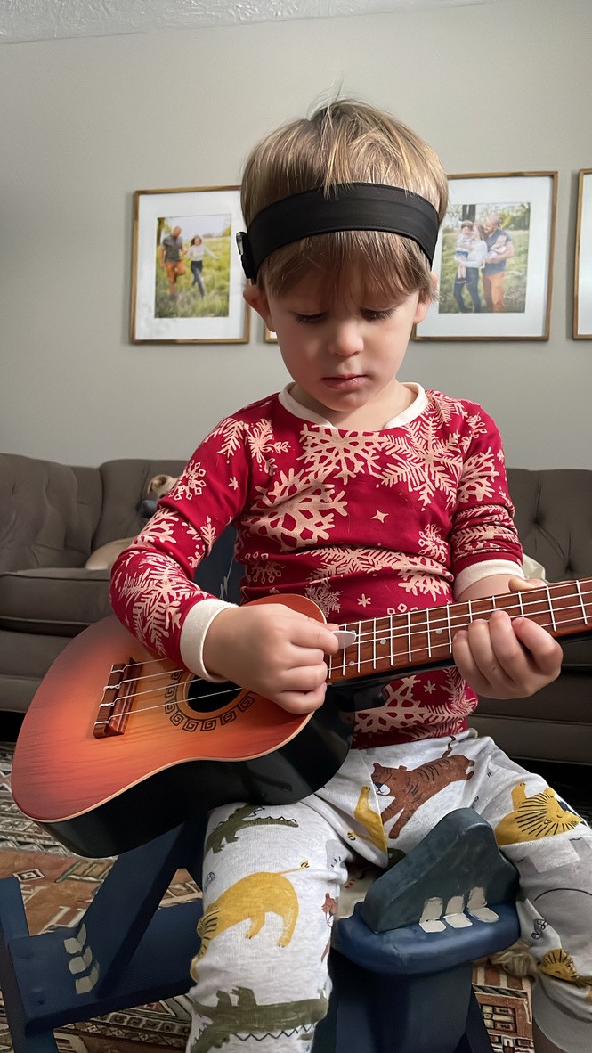 Otto, who has hearing loss from meningitis, with his guitar