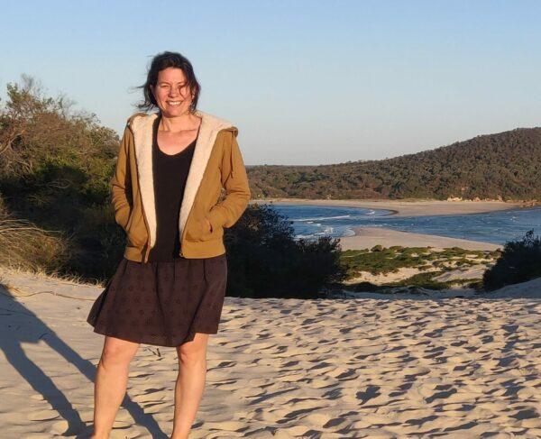 Cochlear employee with hearing loss, Kate, standing on beach