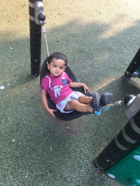 Kiaan, an infant with sensorineural hearing loss in a hammock