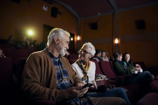 Cochlear's Nucleus 8 Sound Processor, being worn by a man in a movie theater. 