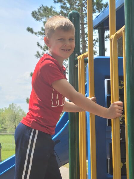 Carson, who failed his newborn hearing test playing on a playground