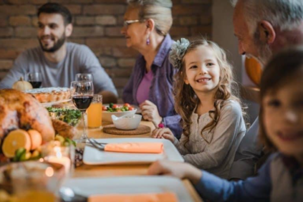 A photo of a holiday gathering with turkey, hearing resources to help you engage.