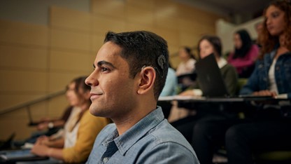 Upgrade sound processor, recipient smiling in class.