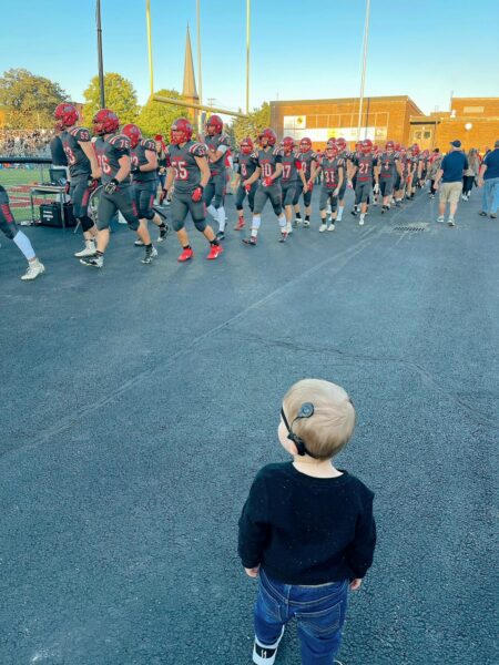 Mathias who failed his auditory brainstem response test watching a football team take the field. 