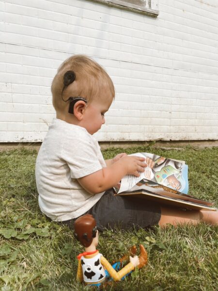 Mathias who failed his auditory brainstem response test, reading a children's book.