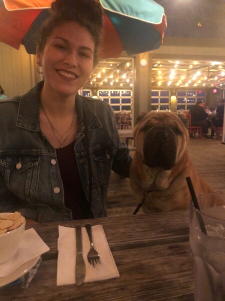 Cochlear employee with hearing loss in Arizona, Emily, with her dog Shiwa at dinner..