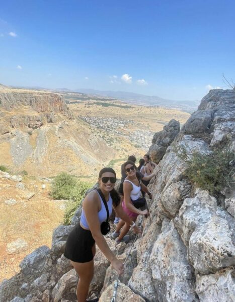 Alana, who is profoundly deaf from connexin 26, hiking with her sister on a rock side. 