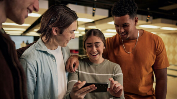 Friends smiling and looking at phone with the new Cochlear Nucleus 8 Sound Processor