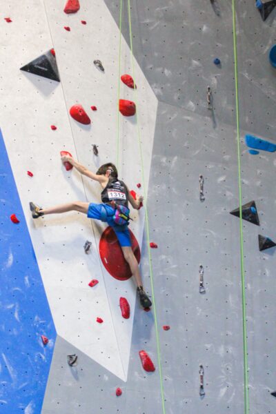 Grayson, who has single sided hearing loss, climbing an indoor rock wall during a competition