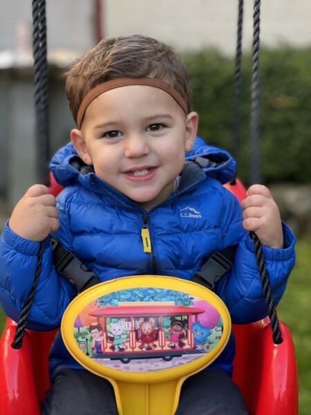 Joey who has profound hearing loss with gjb2 smiling in a swing. 