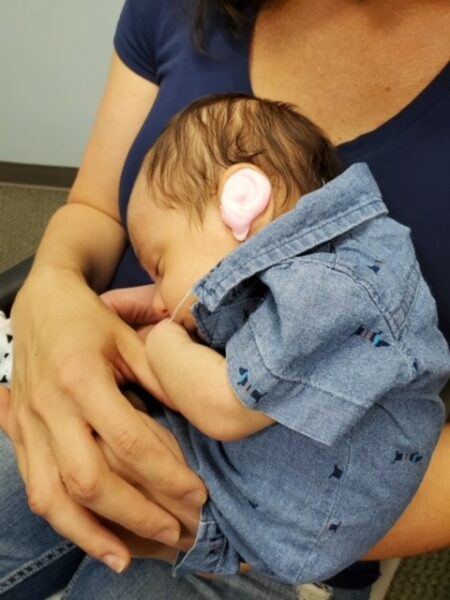 Miles, whose parents sought early intervention for their child, as a baby being held by his mother. 