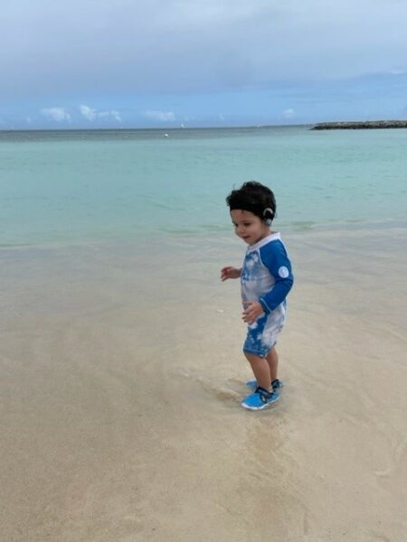 Miles, whose parents sought early intervention for their child, playing on a beach. 
