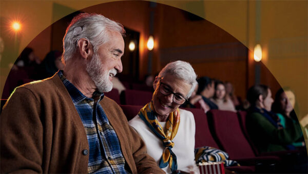 A Nucleus 8 Sound Processor recipient smiling at the movies with his wife; Cochlear tech wish list.