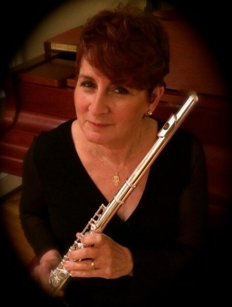 Linda, turned her hearing loss to a hearing win, posing with her flute. 