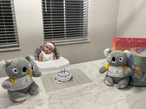 Penelope, who is deaf in both ears, posing with a cake on her cochlear implant activation day. 