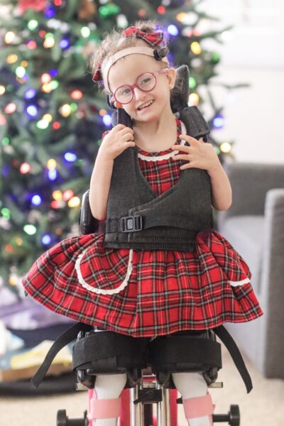 Rose who uses a Baha Sound Processor on a Softband for her Edwards syndrome posing for a Christmas photo.