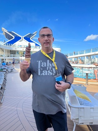 Sam, Cochlear employee with hearing loss. on the cruise ship, holding an ice cream cone