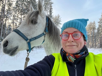 Ulla, Cochlear employee with hearing loss in Finland riding a horse 