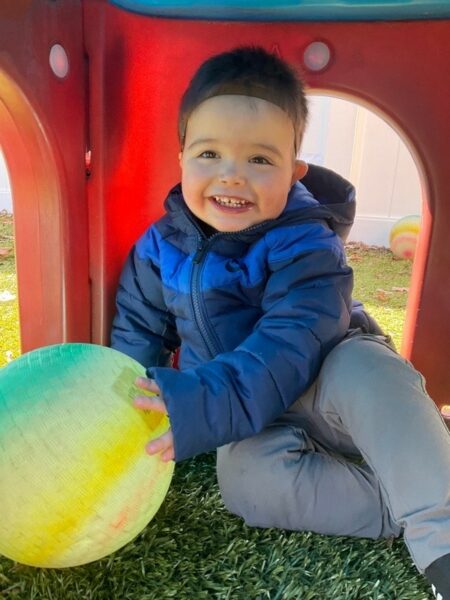 Wyatt, whose Baha System was covered by insurance, playing in a play castle with his Baha Sound Processor on a Softband. 