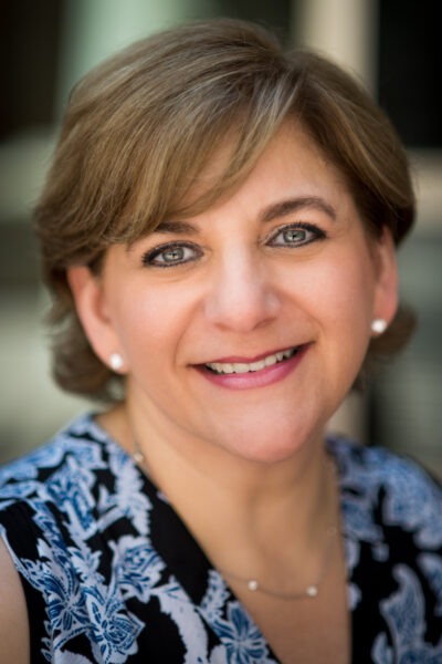 Paula who has confidence from her cochlear implants, posing for a professional headshot photo. 