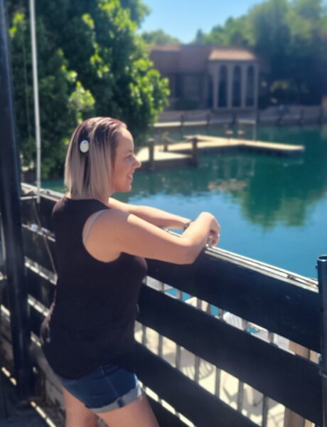 Stephanie posing on a bridge with her Osia System for single-sided deafness