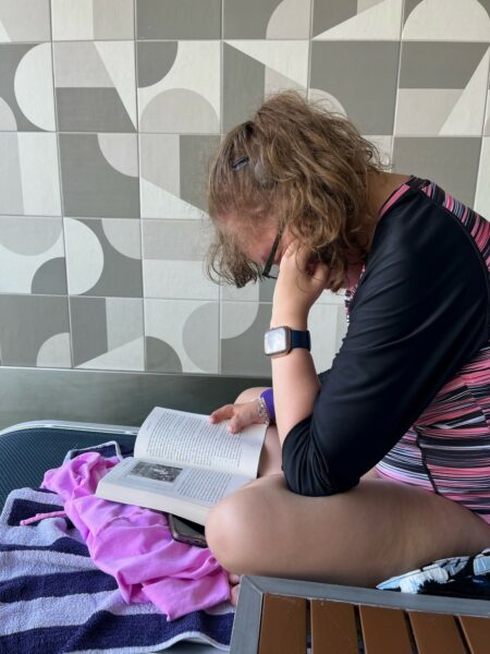 Ashley, who has an Osia Sound Processor for her conductive hearing loss, reading a book. 