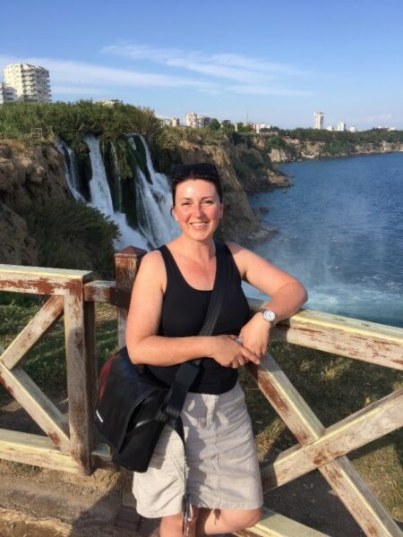 Regina, an Osia implant recipient standing on a bridge in front of a waterfall.