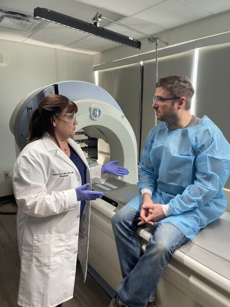 Cochlear implant recipient Debra, speaking with a patient, during her behind-the-scenes video shoot. 