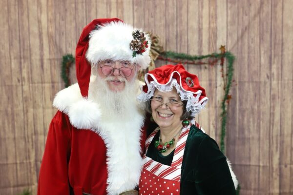 Adele dressed as Mrs. Claus with her husband sharing tips for hearing during the holidays.