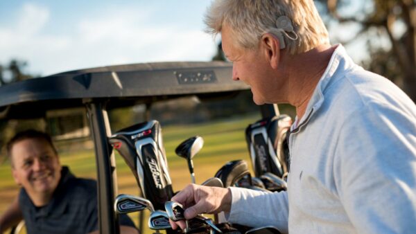 Recipient and friend golfing; over 50 hearing screening checklist.