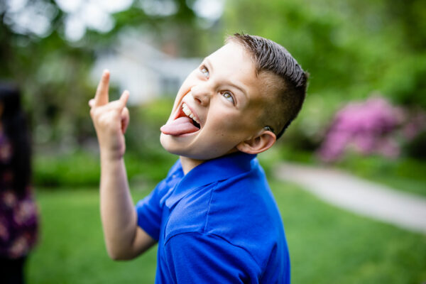 Parker, whose cochlear implant was an option for his single-sided deafness posing for a photo with the "I Love You" sign and his tongue sticking out for a funny picture. 