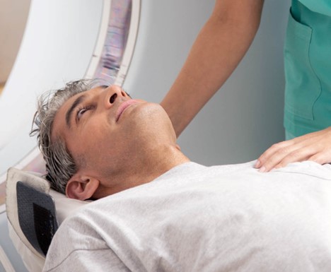 Man shown entering MRI machine; Cochlear implant MRI guidelines