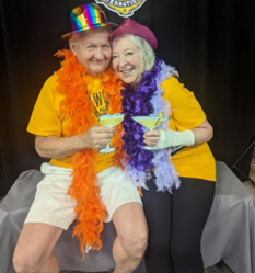 Pictured are Mike and Marcia, who are cochlear volunteers that found love posing for a picture wearing costume accessories. 