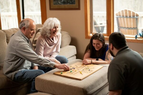Scot, who uses the newest Nucleus 8 Sound Processor technology, sitting with his family playing a board game. 