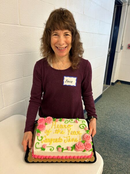 Jane, the 2023 volunteer Hear-o of the year holding her celebratory cake.