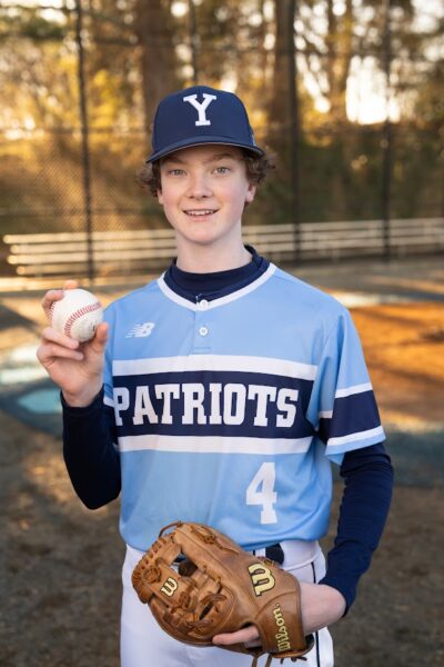 Dylan stands in the baseball field in his sports uniform. His mom shared her back to school tips.