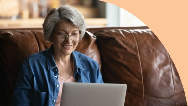 Woman sitting on couch using laptop; online payment portal