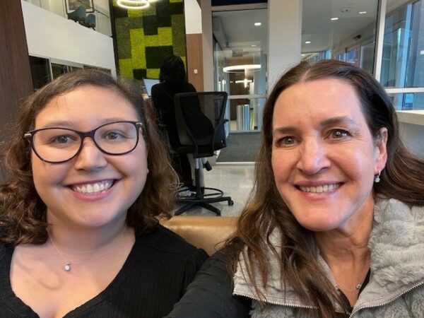 A selfie picture of Taylor, a recipient of the Osia System, and her mom, smiling in the waiting room of her clinic.