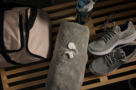 Gym equipment on a bench including a towel, bag, shoes, and water bottle. Hearing with a Cochlear Nucleus 8 Nexa Sound Processor