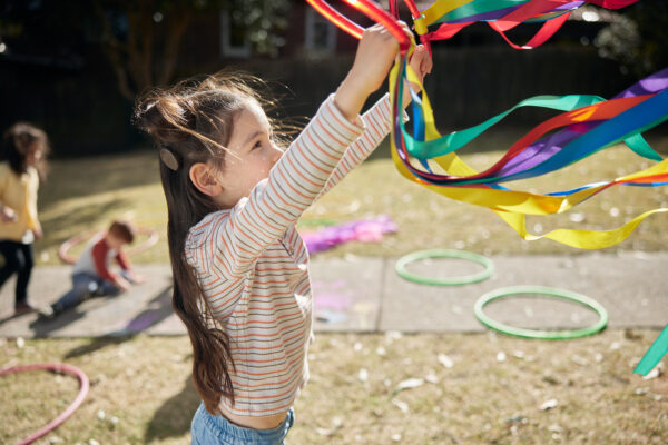A child with a Kanso 3 Sound Processor playing outside with friends.