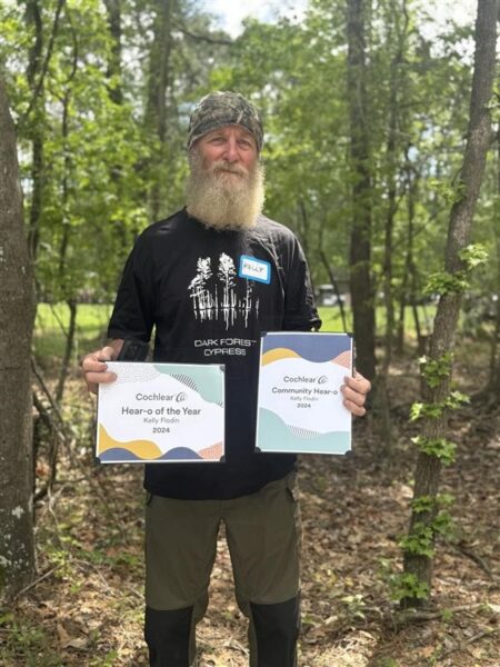 Kelly, a cochlear implant recipient who plays guitar, proudly holds his Hear-o of the Year award.